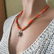 Coral beads on a cord with a pendant of Nautilus