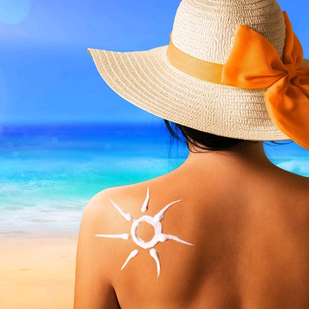 Красивый загар. Защита от солнца. Солнцезащитный крем на пляже. Защита кожи от солнца.