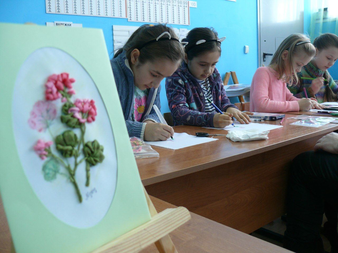 Дети делают свои первые стежки лентами.