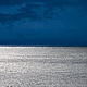 Author's photo - abstract seascape with vivid contrast of silver water and dark blue sky. 