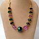 Glamorous necklace of purple, black and emerald green crystal and pearl in Oriental style. Elegant, festive decoration.