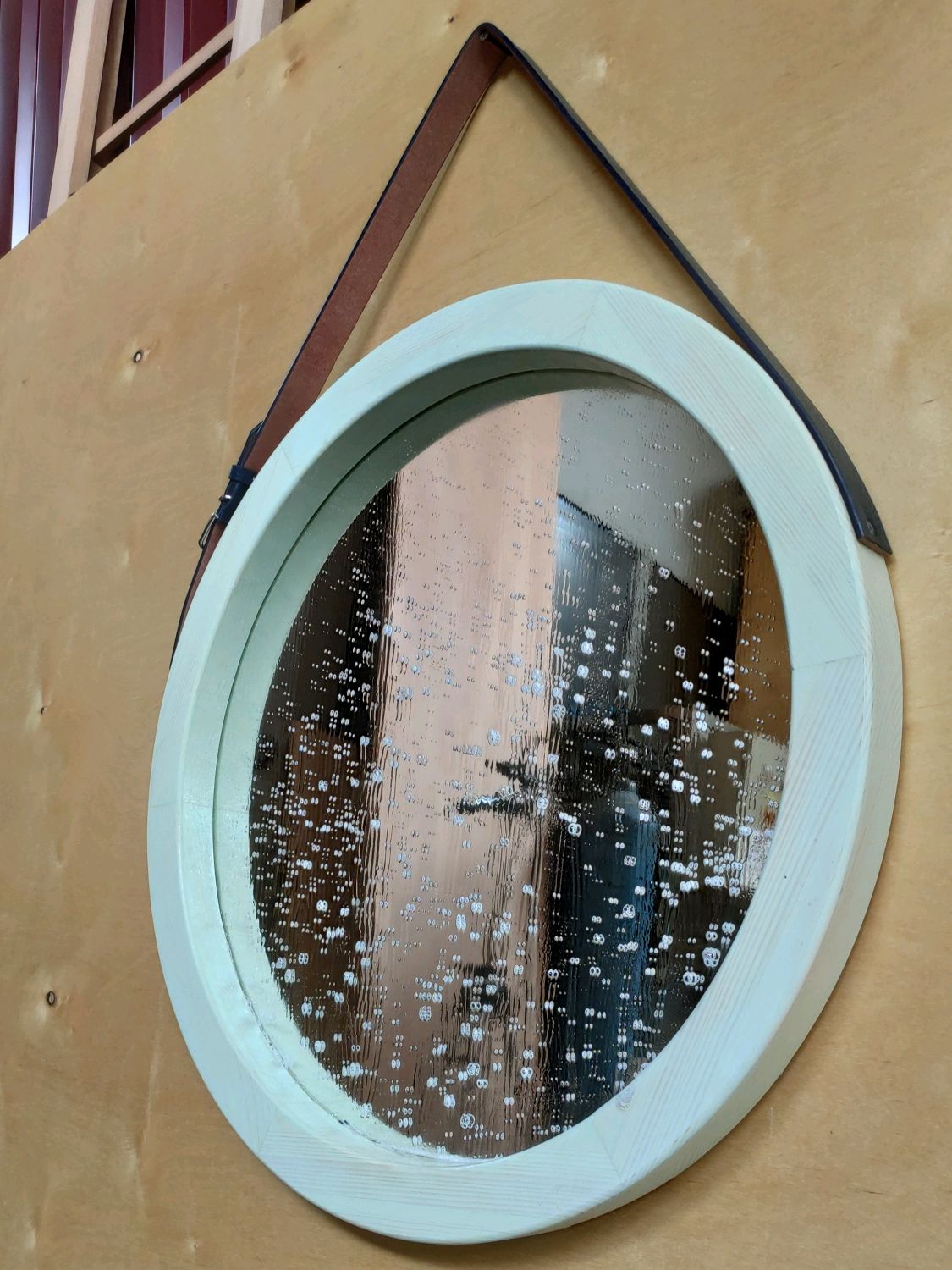 Круглое зеркало на ремне в ванной в интерьере