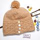 Knitted hat with an openwork bezel in beige tones is made of yarn roving type with the effect of `felting`.
