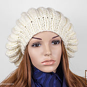 Knitted women's cap with fur pompom