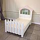 Детская кроватка в светлых молочных тонах для сладких снов ребенка. Выполнена из двух частей: Первая - сама кровать с изножьем. Вторая-шкаф-домик, служит изголовьем.