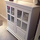White sideboard for storage of utensils, towels and other things. Has three big shelves. Facades doors with glass inserts. The buffet is not too high, allowing you to use the countertop.