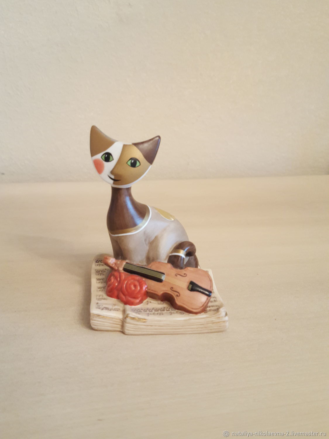 Статуэтка кошка на полку со свисающей лапой