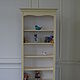 Tall bookcase with six open shelves. Decorative flutings and a scalloped frame under the eaves.